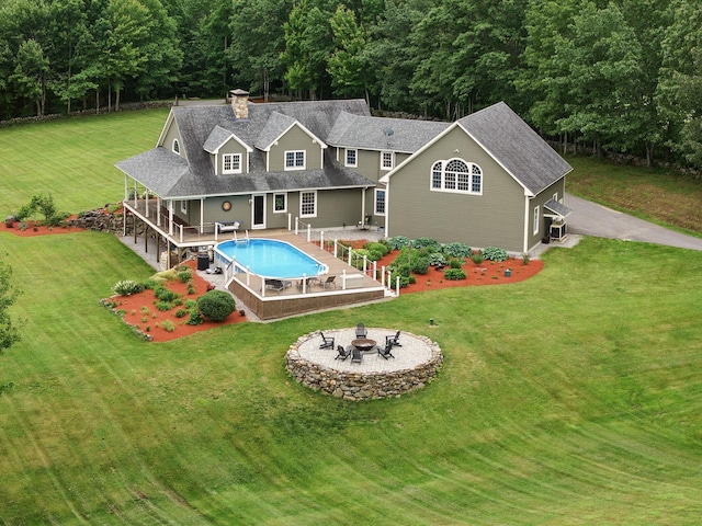 84 Shaw Rd, Northfield, NH 03276 - back of house with a fire pit, an outdoor pool, a lawn, a patio, and roof with shingles