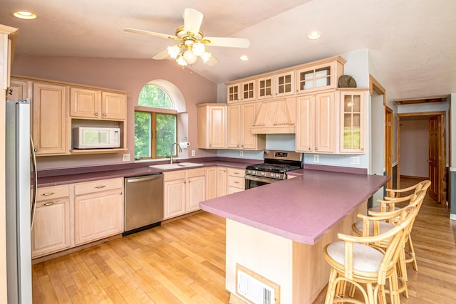 98 Rowell Rd, Lancaster, NH 03584 - kitchen with stainless steel appliances, custom range hood, vaulted ceiling, a peninsula, and a kitchen bar