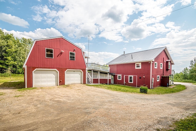 98 Rowell Rd, Lancaster, NH 03584 - view of property exterior featuring driveway, a gambrel roof, a detached garage, a barn, and a metal roof