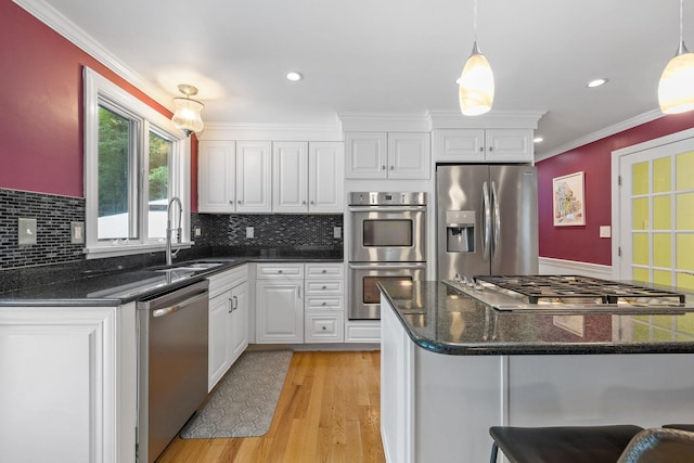 397 Strafford Rd, Strafford, NH 03844 - kitchen with appliances with stainless steel finishes, white cabinetry, light wood-style flooring, backsplash, and hanging light fixtures