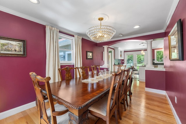 397 Strafford Rd, Strafford, NH 03844 - dining space with ornate columns, arched walkways, ornamental molding, light wood-style flooring, and a chandelier