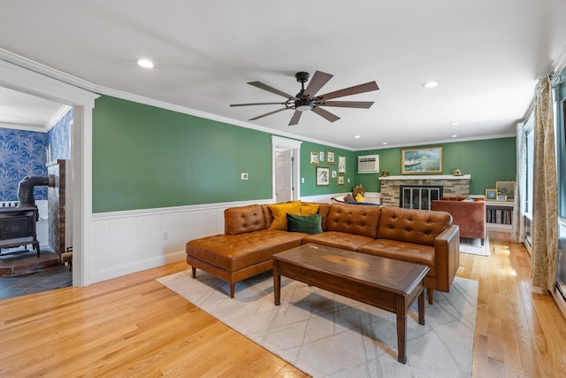 397 Strafford Rd, Strafford, NH 03844 - living room featuring light wood finished floors, ceiling fan, a wainscoted wall, crown molding, and a wood stove
