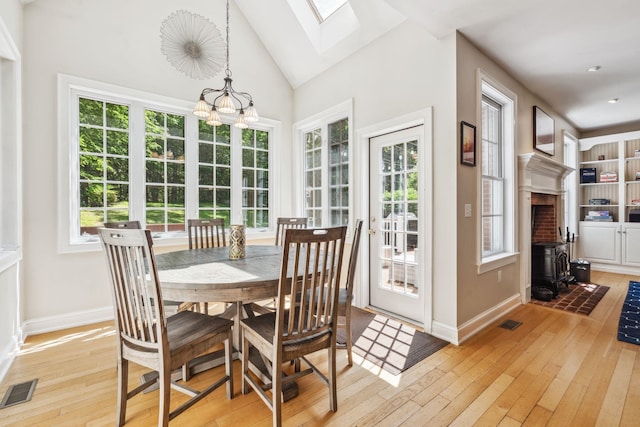 6 Walters Way, Exeter, NH 03833 - dining room with light wood-style flooring, a skylight, a chandelier, a wood stove, and vaulted ceiling