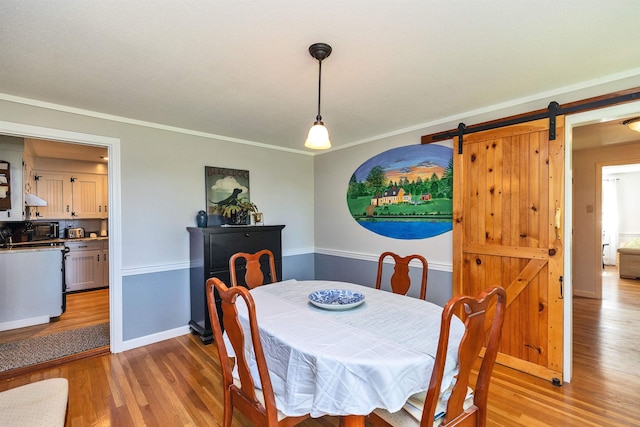 76 Cunningham Pond Rd, Peterborough, NH 03458 - dining space with light wood-style flooring, a barn door, and crown molding