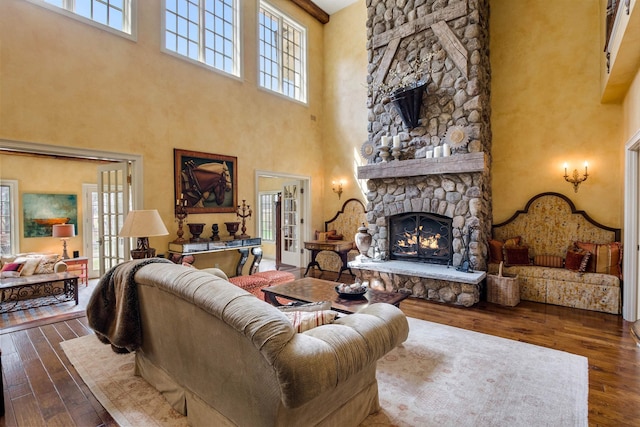44 Buker Way, New London, NH 03257 - living area featuring a towering ceiling, a stone fireplace, healthy amount of natural light, and hardwood / wood-style flooring