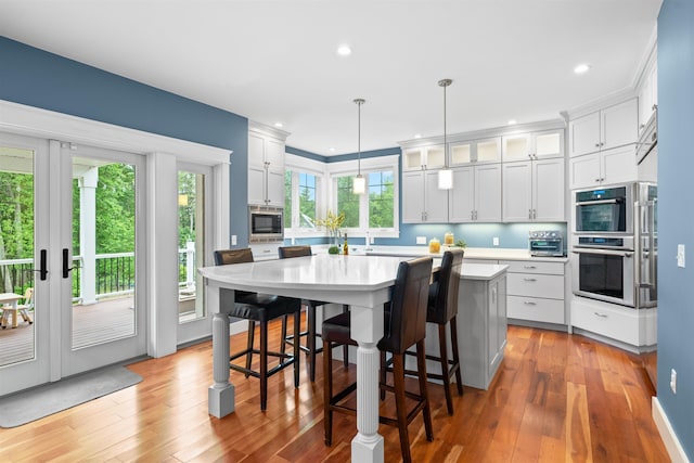 74 Childs Dr, Dover, NH 03820 - kitchen featuring appliances with stainless steel finishes, light countertops, light wood-type flooring, a center island, and recessed lighting
