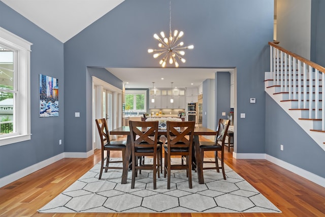 74 Childs Dr, Dover, NH 03820 - dining room with stairs, light wood finished floors, a chandelier, and high vaulted ceiling