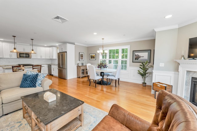 61 Acadia Ln Unit 309, Exeter, NH 03833 - living area featuring recessed lighting, light wood-style floors, a chandelier, ornamental molding, and a tile fireplace