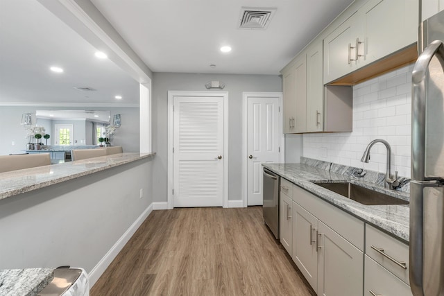 61 Acadia Ln Unit 309, Exeter, NH 03833 - kitchen featuring stainless steel appliances, decorative backsplash, light wood finished floors, recessed lighting, and light stone counters