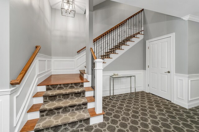 61 Acadia Ln Unit 309, Exeter, NH 03833 - stairs featuring a decorative wall, wainscoting, and a chandelier