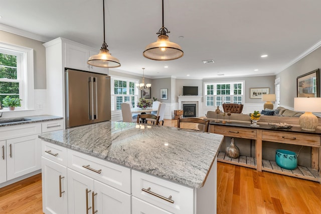 61 Acadia Ln Unit 309, Exeter, NH 03833 - kitchen featuring high quality fridge, ornamental molding, light wood-style floors, open floor plan, and light stone countertops