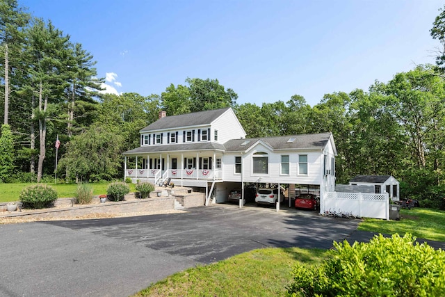 11 Parkside Dr, Pelham, NH 03076 - view of front facade with covered porch, a chimney, asphalt driveway, and view of wooded area