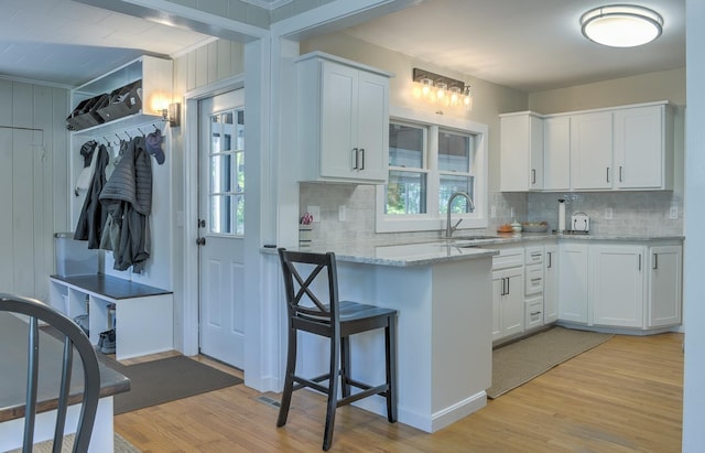 67 Pine Ave, Keene, NH 03431 - kitchen with light wood finished floors, tasteful backsplash, light stone counters, and white cabinetry