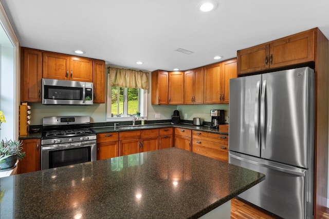 450 Ryan Rd, Duxbury, VT 05676 - kitchen with stainless steel appliances, brown cabinetry, recessed lighting, and dark stone counters