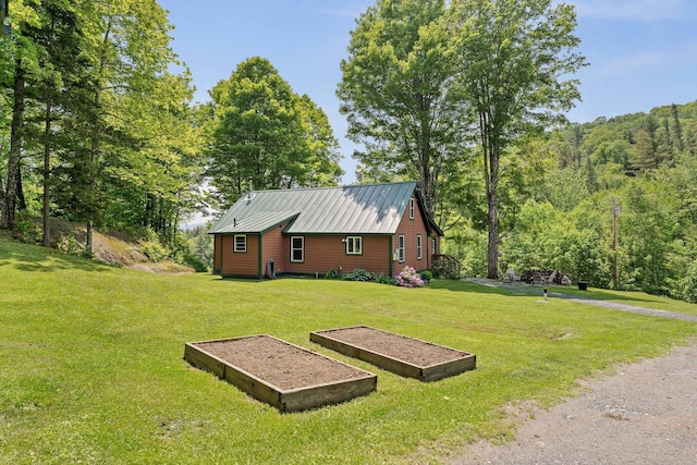 450 Ryan Rd, Duxbury, VT 05676 - view of side of home featuring a lawn, a garden, and a metal roof