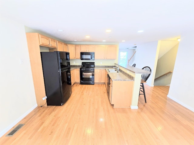 69 Mulberry St Unit 3, Concord, NH 03301 - kitchen with black appliances, a peninsula, light brown cabinets, light wood-style flooring, and recessed lighting