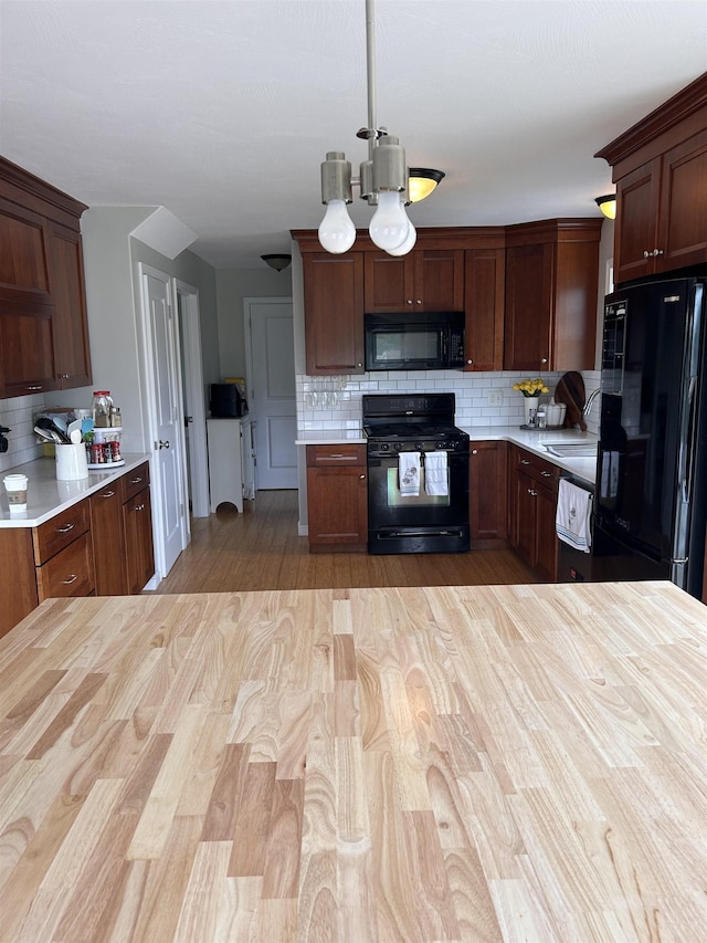 81 Cider St, Epping, NH 03042 - kitchen with black appliances, light countertops, tasteful backsplash, and light wood-style floors
