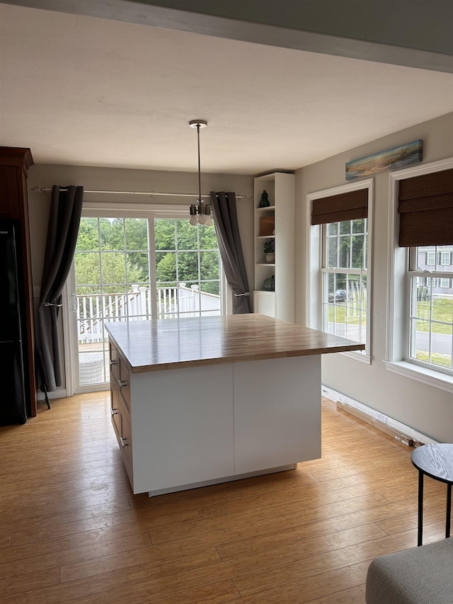 81 Cider St, Epping, NH 03042 - kitchen with white cabinetry, light wood-style flooring, hanging light fixtures, and a kitchen island
