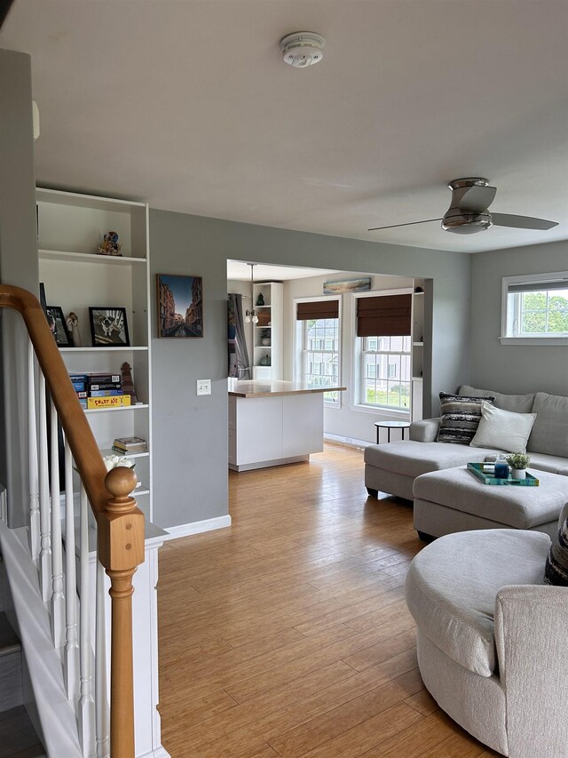 81 Cider St, Epping, NH 03042 - living room with light wood finished floors, ceiling fan, and stairway
