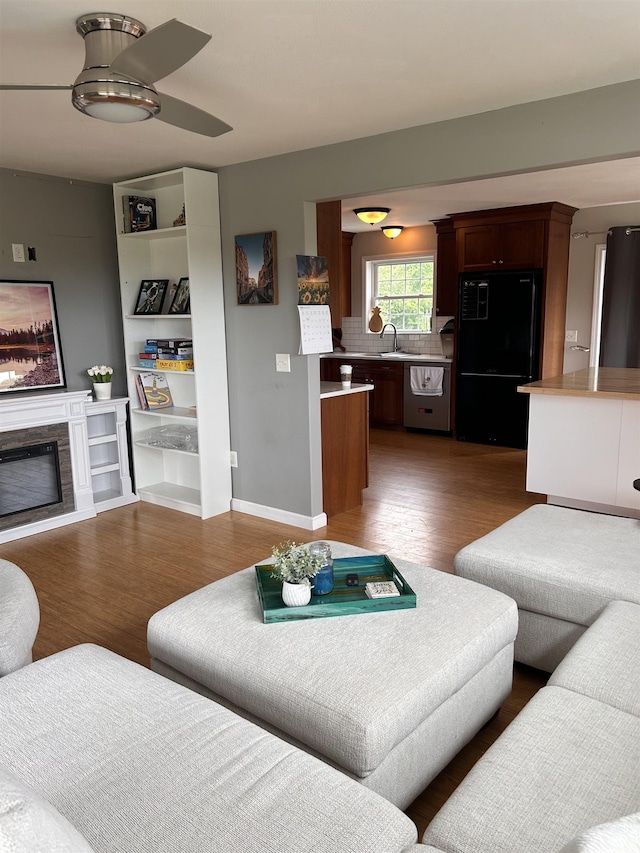 81 Cider St, Epping, NH 03042 - living area featuring wood finished floors, a glass covered fireplace, ceiling fan, and built in features