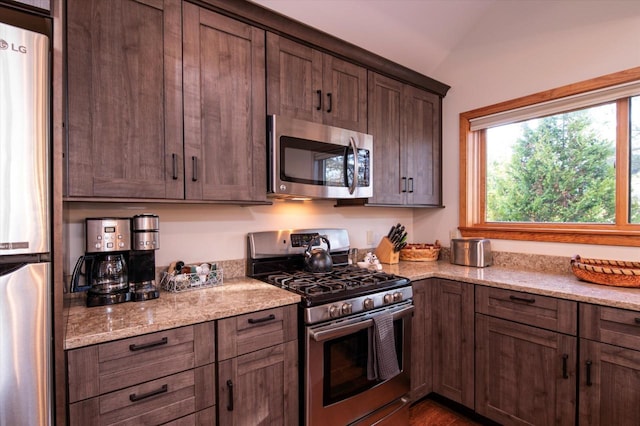 36 Lower Iv Unit 48A, Ludlow, VT 05149 - kitchen featuring appliances with stainless steel finishes, light stone countertops, and dark brown cabinetry
