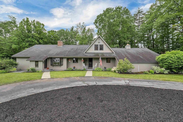 13 Kelso Dr, Bow, NH 03304 - view of front of home with a chimney, a front yard, covered porch, and driveway