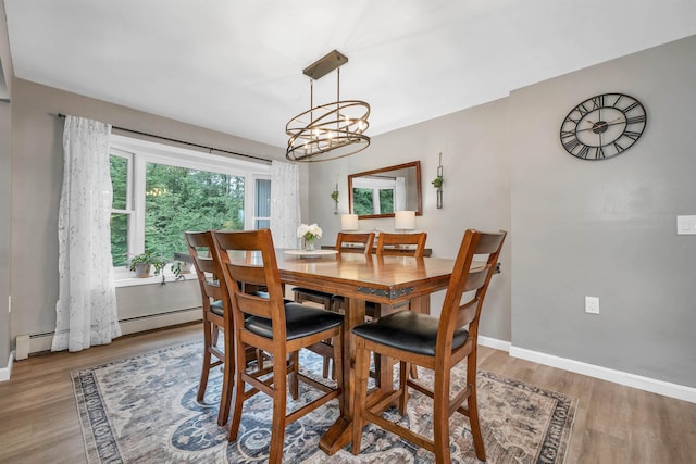 13 Kelso Dr, Bow, NH 03304 - dining space featuring wood finished floors, a chandelier, and a baseboard radiator