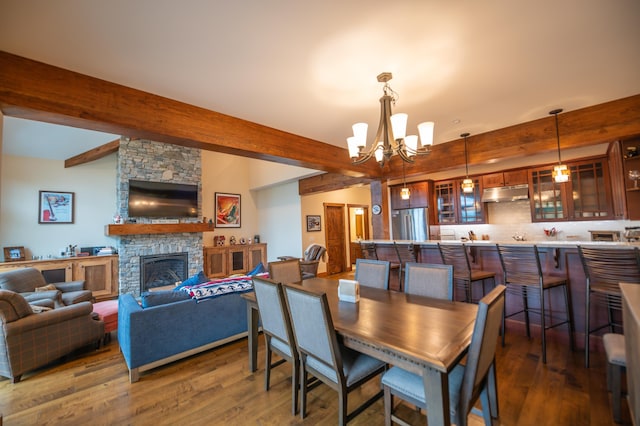 3B Freestyle Cir, Dover, VT 05356 - dining room featuring a chandelier, beamed ceiling, dark wood-style flooring, and a fireplace