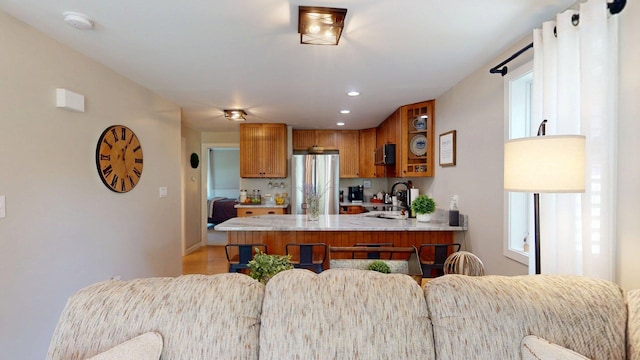 501 Bean Hill Rd Unit 32, Northfield, NH 03276 - kitchen featuring freestanding refrigerator, brown cabinetry, a peninsula, light wood finished floors, and recessed lighting