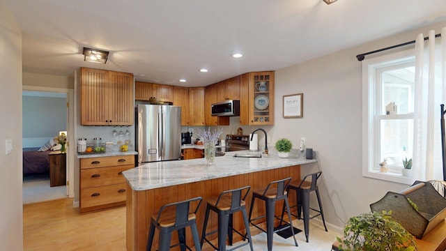 501 Bean Hill Rd Unit 32, Northfield, NH 03276 - kitchen with stainless steel appliances, a peninsula, light stone counters, glass insert cabinets, and recessed lighting