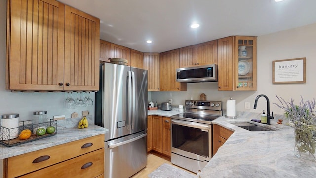 501 Bean Hill Rd Unit 32, Northfield, NH 03276 - kitchen with stainless steel appliances, light stone counters, glass insert cabinets, brown cabinets, and recessed lighting