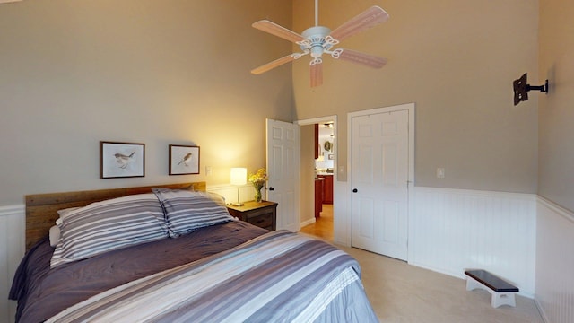 501 Bean Hill Rd Unit 32, Northfield, NH 03276 - bedroom featuring a wainscoted wall, light carpet, a high ceiling, and a closet