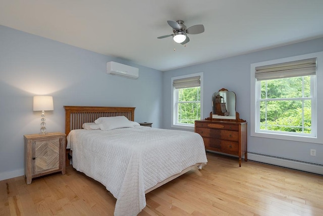 52 Jeffrey Dr, Sunapee, NH 03782 - bedroom with an AC wall unit, a baseboard radiator, light wood finished floors, and a ceiling fan