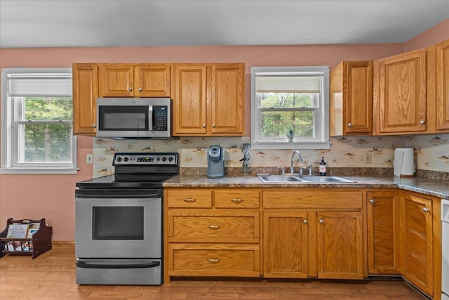 89 Catella Rd, Essex, VT 05452 - kitchen with stainless steel appliances, light wood-style floors, dark countertops, and brown cabinets