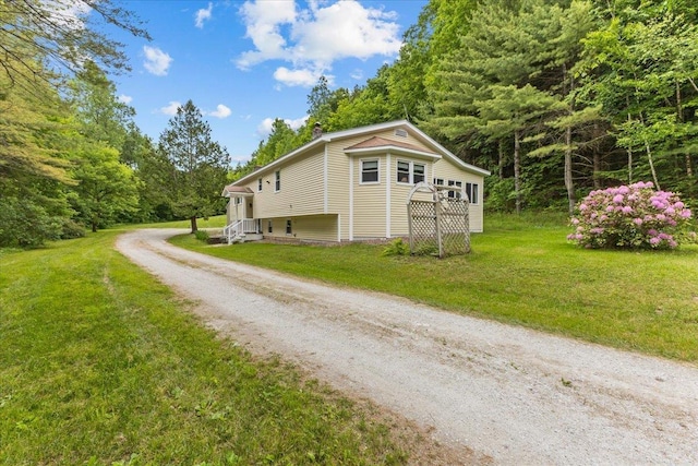 89 Catella Rd, Essex, VT 05452 - view of property exterior featuring driveway, a yard, and a forest view