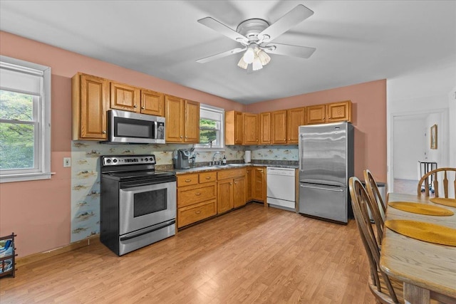 89 Catella Rd, Essex, VT 05452 - kitchen with appliances with stainless steel finishes, light wood-style flooring, ceiling fan, decorative backsplash, and brown cabinetry