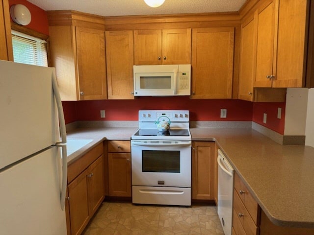 122 Batchelder St Unit A-8, Barre City, VT 05641 - kitchen with white appliances, light countertops, and brown cabinetry