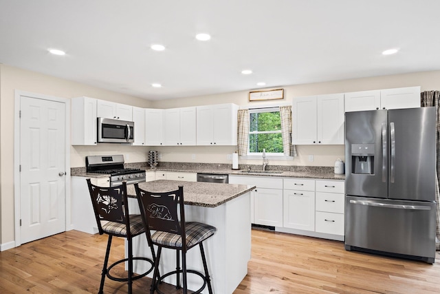 121 Deer Run Rd, Middleton, NH 03887 - kitchen featuring appliances with stainless steel finishes, a breakfast bar area, white cabinets, and recessed lighting