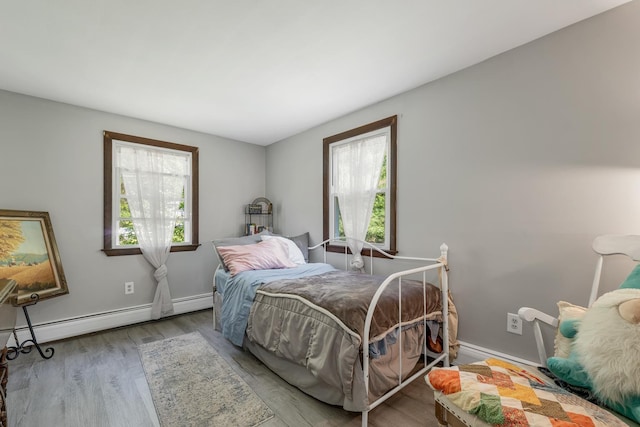 73 Tall Pine Rd, Farmington, NH 03835 - bedroom featuring multiple windows, a baseboard radiator, and wood finished floors