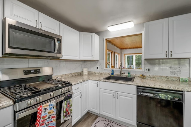 73 Tall Pine Rd, Farmington, NH 03835 - kitchen featuring appliances with stainless steel finishes, light wood-style floors, white cabinets, decorative backsplash, and wood ceiling