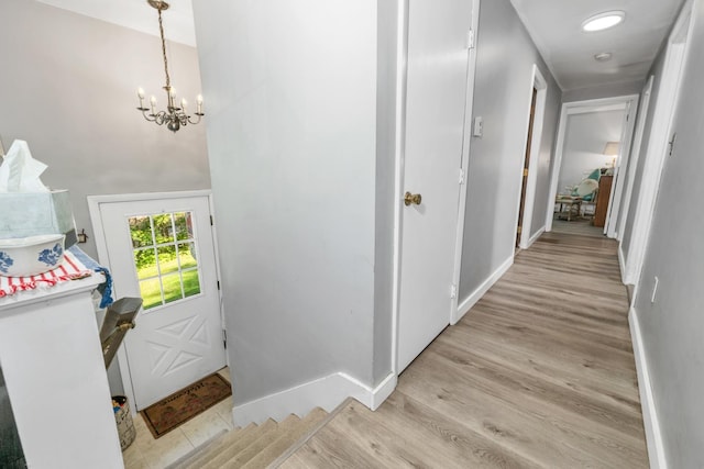 73 Tall Pine Rd, Farmington, NH 03835 - hallway featuring light wood-style flooring and a chandelier