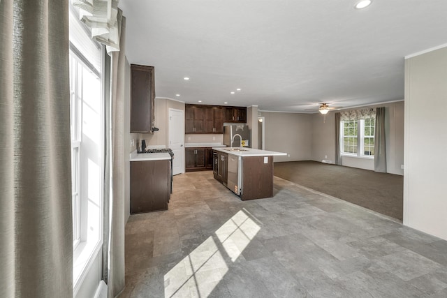 106 Stevens Rd Unit 1, Effingham, NH 03882 - kitchen featuring light countertops, open floor plan, ceiling fan, a kitchen island with sink, and dark brown cabinetry