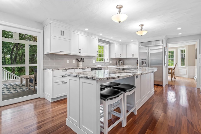 65 Forest St, Londonderry, NH 03053 - kitchen featuring appliances with stainless steel finishes, wood finished floors, white cabinetry, a center island, and recessed lighting