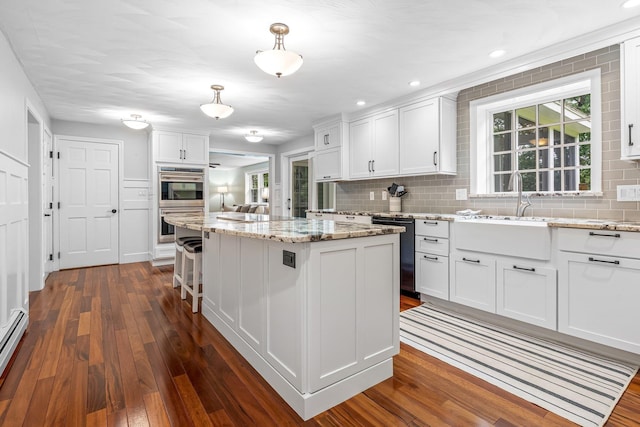 65 Forest St, Londonderry, NH 03053 - kitchen with dishwasher, stainless steel double oven, dark wood-style floors, a kitchen island, and recessed lighting