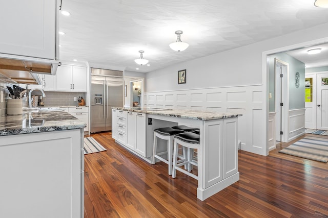 65 Forest St, Londonderry, NH 03053 - kitchen with built in fridge, a center island, white cabinetry, dark wood finished floors, and recessed lighting