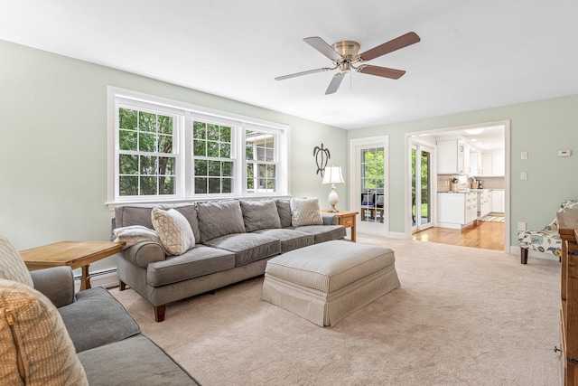 65 Forest St, Londonderry, NH 03053 - living area with a baseboard heating unit, light carpet, and a ceiling fan