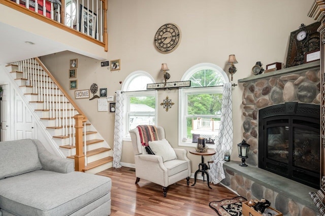 57 Rutland St, Dover, NH 03820 - living area featuring stairway, wood finished floors, a towering ceiling, and a stone fireplace