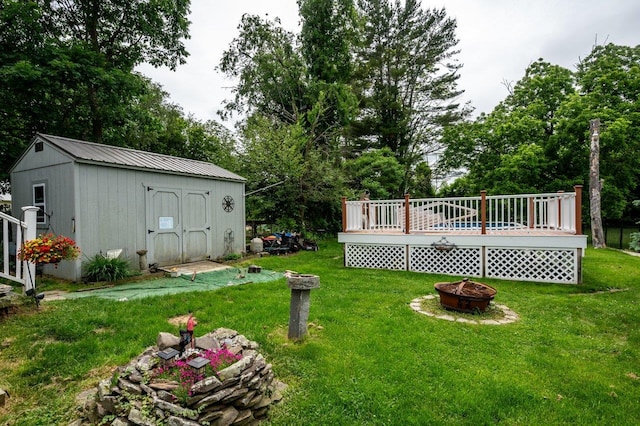 57 Rutland St, Dover, NH 03820 - view of grassy yard with a fire pit, a deck, and a storage unit