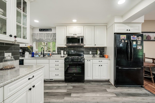 57 Rutland St, Dover, NH 03820 - kitchen with black appliances, backsplash, white cabinets, recessed lighting, and light stone counters