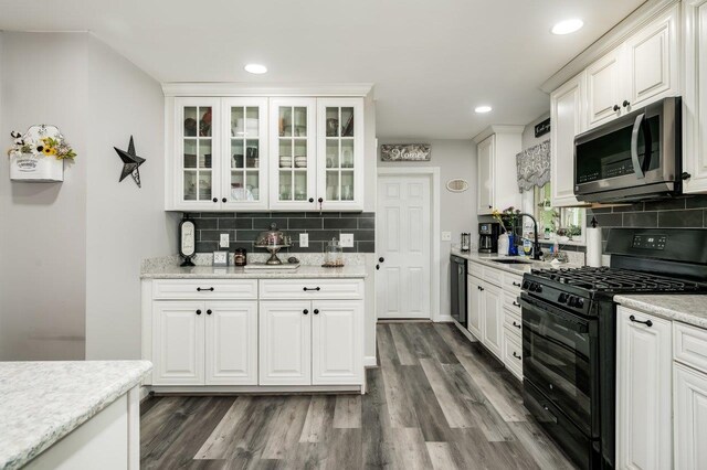 57 Rutland St, Dover, NH 03820 - kitchen with black appliances, decorative backsplash, white cabinets, dark wood-type flooring, and recessed lighting